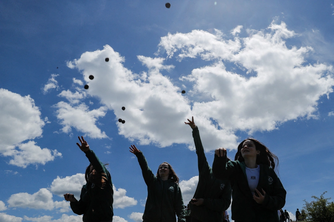 Children throw seeds on the first day of drone reforestation in Butovc, Kosovo May 13, 2024. REUTERS/Valdrin Xhemaj