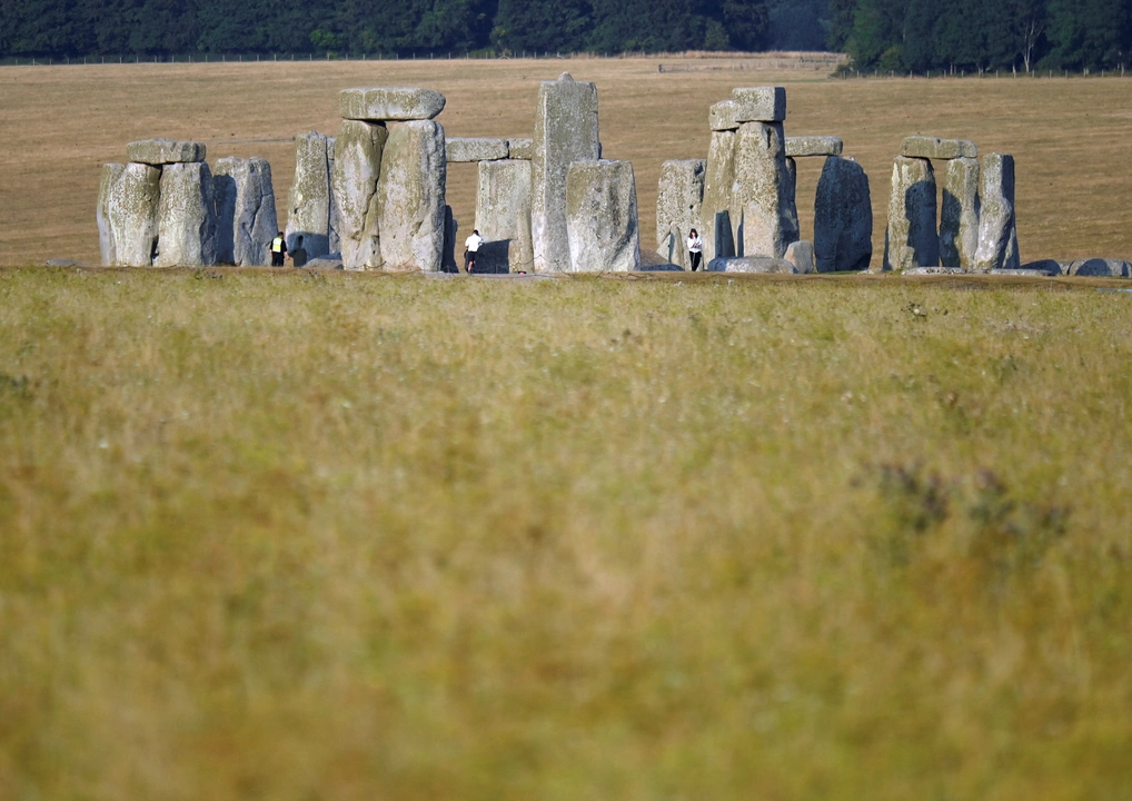 People walk around the Stonehenge stone circle, in this file photo, in Amesbury, Britain, August 12, 2022. REUTERS/Toby Melville/File Photo